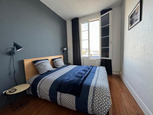 1 dormitorio con 1 cama con manta azul y blanca en "L'amarrage" 2 chambres Perret Pleine Vue Mer en Le Havre