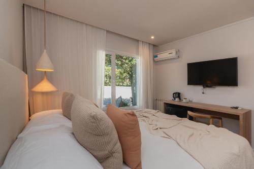 a bedroom with a bed and a tv on the wall at Hostería & Spa De La Cascada in Tandil