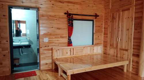 a wooden room with a bench and a window at Higland Homestay Bac Ha in Bắc Hà