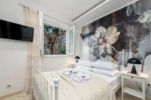 sypialnia z łóżkiem i malowidłem ściennym w obiekcie Apartment Barbara with Private pool w Dubrowniku