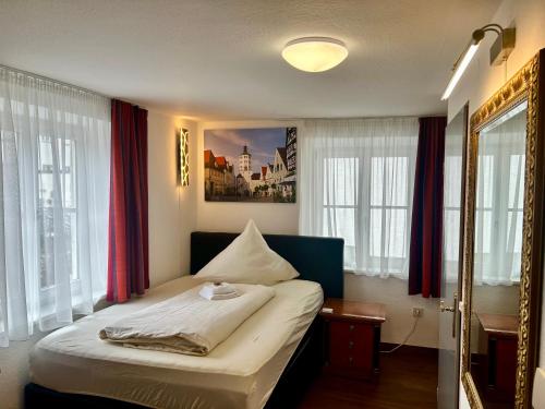 1 dormitorio con 1 cama con una foto en la pared en Brauereigasthof zur Münz seit 1586, en Günzburg