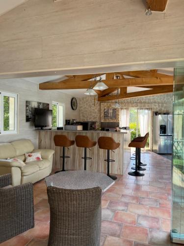 un salon avec un canapé et une table dans l'établissement Séjours à partir de 3 nuitées villa avec piscine à débordement, Spa et Pool house, à Bagnols-en-Forêt