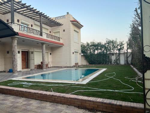 a house with a swimming pool in the yard at El dakroury king mariout villa in Naj‘ al Aḩwāl