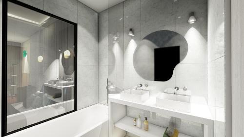 een badkamer met 2 wastafels en een spiegel bij Les Vagues Hotel & Spa in Arcachon