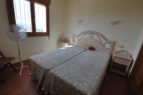 - une chambre avec un lit, une fenêtre et un ventilateur dans l'établissement Villa Higeron, à Cumbre del Sol