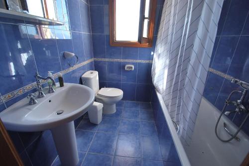 La salle de bains bleue est pourvue d'un lavabo et de toilettes. dans l'établissement Villa Higeron, à Cumbre del Sol