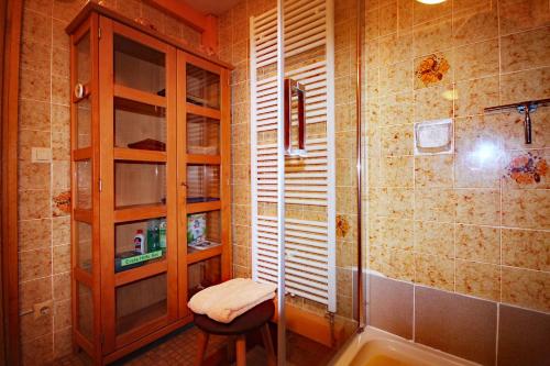 a bathroom with a shower and a stool and a toilet at Apartment-Pension Im Eichenweg in Waldachtal