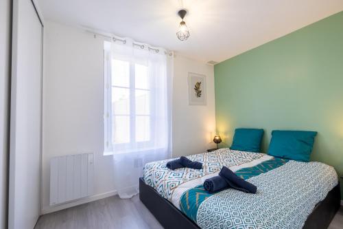 une chambre avec un lit avec des oreillers bleus dessus dans l'établissement Très Bel Appartement Cosy et Central, à Cholet