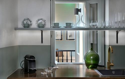 półka z kieliszkami i butelką na stole w obiekcie Stunning Athens Apartment | 1 Bedroom | Apartment Juvia | Athinaidos w Atenach
