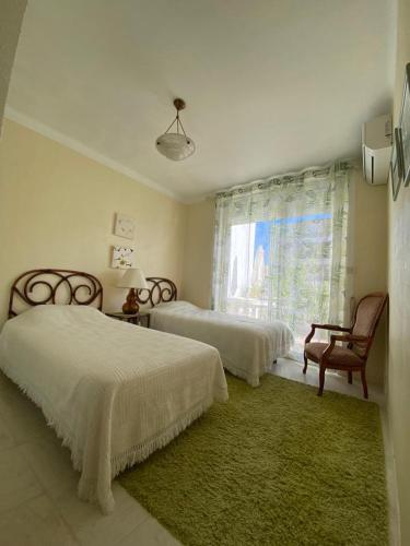 une chambre avec deux lits et une chaise et une fenêtre dans l'établissement 3 Pièces avec grande terrasse, à Cannes