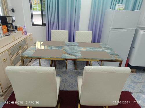 cocina con mesa, sillas y nevera en Ontrack Travel Transit Hotel, en Male
