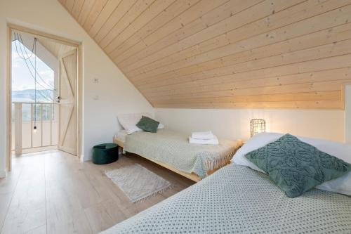 2 letti in una camera con soffitto in legno di Beskid Sielski - klimatyczne domki w Lipowej z widokiem na góry i sauną - Dream Apart a Żywiec