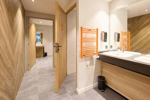 een badkamer met 2 wastafels en een grote spiegel bij Hotel Base Camp Lodge - Albertville in Albertville