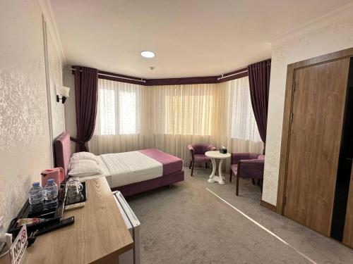 pokój hotelowy z łóżkiem i stołem w obiekcie Aurora Hotel w Taszkiencie