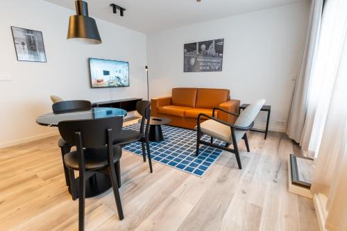 a living room with a couch and a table and chairs at Hlemmur Suites in Reykjavík
