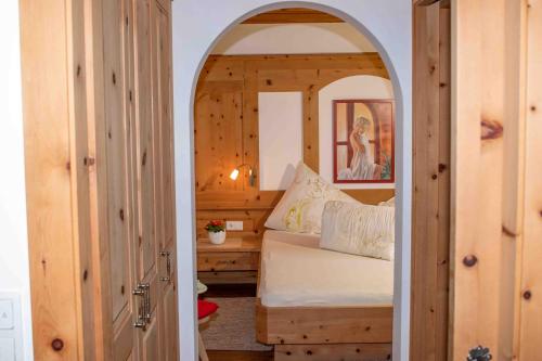 a bedroom with a bed with an archway in it at Obstbauernhof Fohlenhof in Lasa