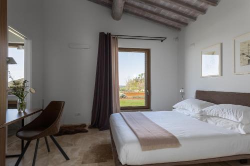 a bedroom with a bed and a desk and a window at Villa Velari In Volterra With Private Pool, AC in Volterra