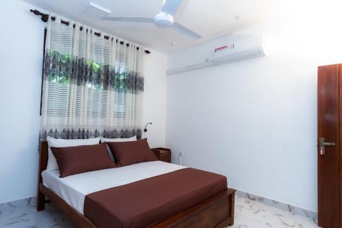 a bedroom with a bed and a window at The Islands Breeze Villa in Dehiwala