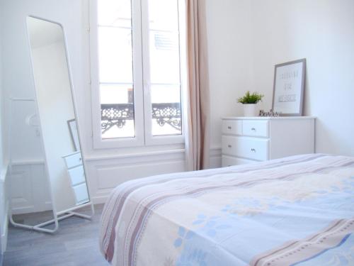 トロワにあるBel Appartement Coeur de Villeの白いベッドルーム(ベッド1台、窓付)