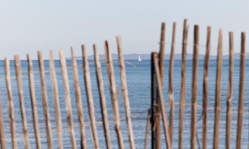 una recinzione sulla spiaggia vicino all'acqua di Le Domaine de la mer - Appartements de plage dans un cadre enchanteur a Hyères