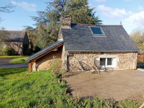 a stone house with two chairs in front of it at Ar Maen in Lanvollon