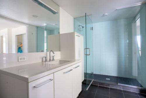 a bathroom with a sink and a glass shower at Blueground DTLA pool courtyard near dining LAX-1202 in Los Angeles