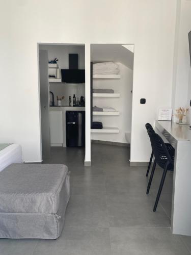 Cet appartement comprend une chambre avec un lit et une cuisine avec une table. dans l'établissement Asteras Mini Suites, à Náoussa