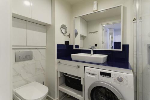 a bathroom with a washing machine and a sink at Elite Class Sea View Aparthotel In Orbi City Batumi in Batumi