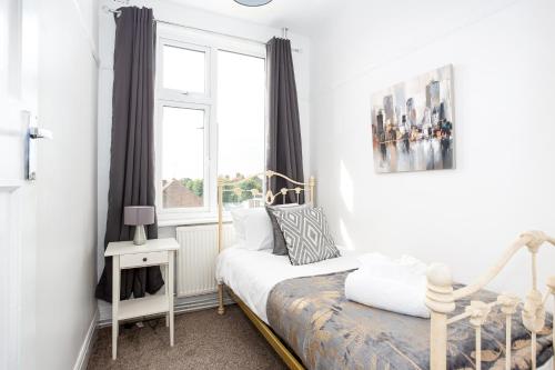een kleine slaapkamer met een bed en een raam bij Large 4 Bed in Southend, near shops/cafés/beach! in Southend-on-Sea