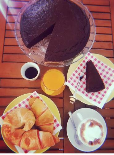 Una mesa con un pastel de chocolate y pasteles en platos. en L'ARCO ANTICO - Una Casa sul Mare, en Polignano a Mare