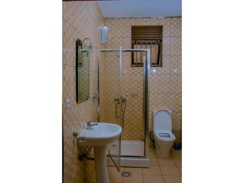 La salle de bains est pourvue d'un lavabo et de toilettes. dans l'établissement Igitego Hotel Remera, à Kigali