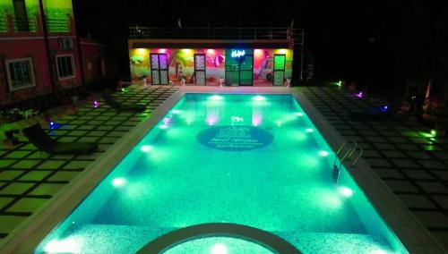 una piscina por la noche con luces. en Resort Neel Nirjan, en Bolpur