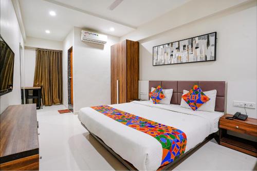 um quarto com uma grande cama branca e uma secretária em FabHotel La Victoria em Surate