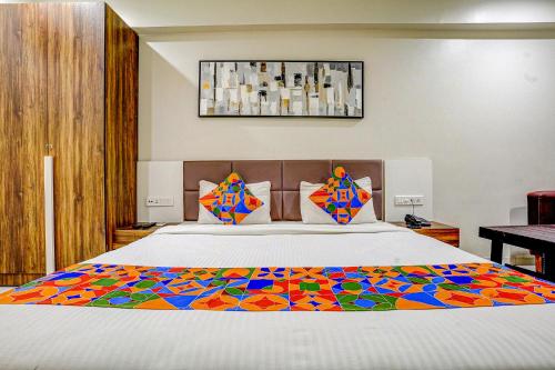 um quarto com uma cama grande e um edredão colorido em FabHotel La Victoria em Surate
