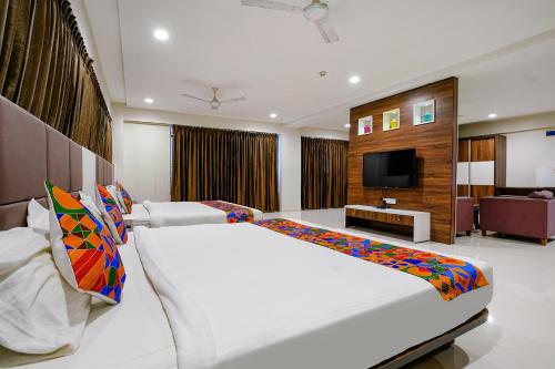 a bedroom with a large bed and a television at FabHotel La Victoria - Galaxy Circle in Surat