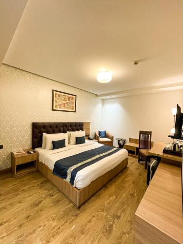 a bedroom with a large bed and a desk at Hotel 91 Huda City Centre in Gurgaon