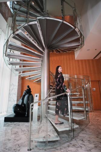 a woman standing on a staircase in a room at Ritz Carlton DIFC Downtown Dubai in Dubai