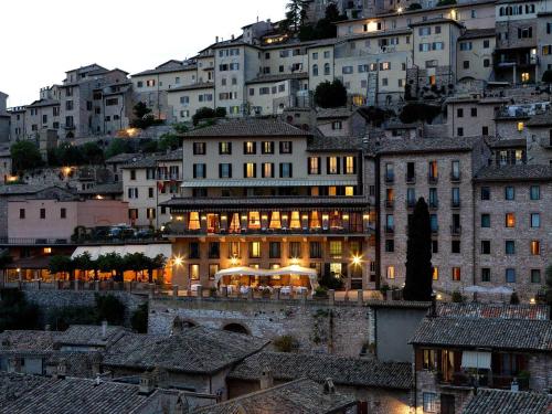 un groupe de bâtiments de nuit dans une ville dans l'établissement Giotto Hotel & Spa, à Assise