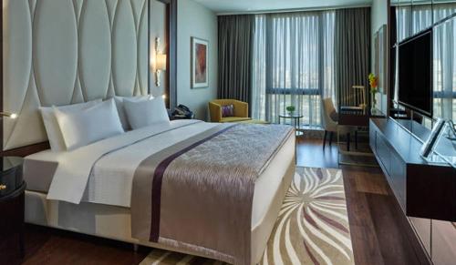 a hotel room with a large bed and a television at Elite World Grand Istanbul Basın Ekspres in Istanbul