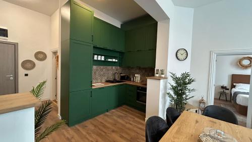 uma cozinha com armários verdes e uma mesa num quarto em Historical Center Residence Sofia em Sófia