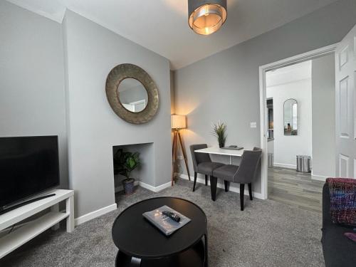a living room with a television and a dining room at Flat 1 Castle Street Serviced Apartments in Telford