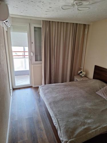 a bedroom with a bed and a large window at Appartment in Zenica