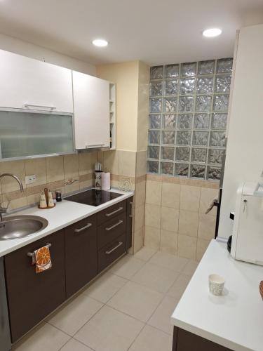 a kitchen with brown cabinets and a sink at Appartment in Zenica