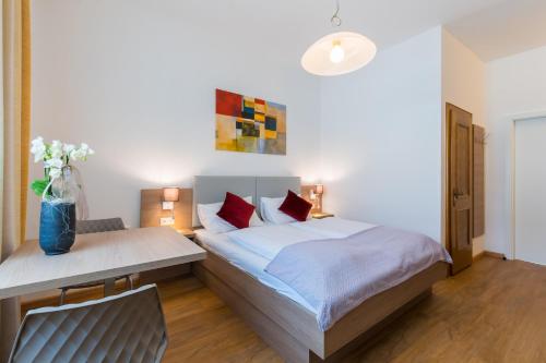 ein Schlafzimmer mit einem Bett, einem Tisch und einem Stuhl in der Unterkunft Berghamer's Gasthof Hotel in Neukirchen am Walde