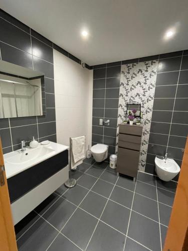 a bathroom with two sinks and a toilet at GARDEN & BEACH HOUSE in Figueira da Foz