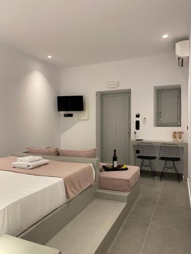 a bedroom with two beds and a flat screen tv at Asteras Mini Suites in Naousa