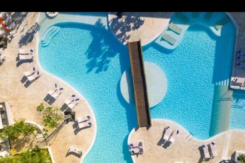 an overhead view of a pool with chairs and umbrellas at Casa en Villas Jubey con acceso al Hotel Emotion By Hodelpa in Juan Dolio