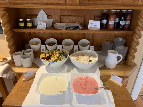 a counter with bowls of food on a table at Hotel Haferland in Wieck