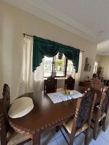 a dining room with a wooden table and chairs at Loidas Place in Talisay