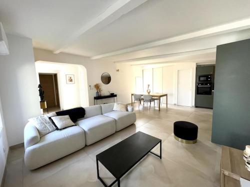 un salon avec un canapé blanc et une table dans l'établissement Charmante maison avec piscine, à Garons